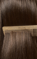 Combing healthy long straight female hair. Close up