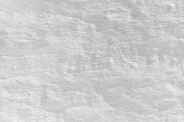 Embossed textured white grunge wall surface painted with whitewash could be used like a layout or background.