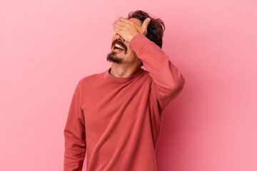 Young caucasian man isolated on pink background covers eyes with hands, smiles broadly waiting for a surprise.