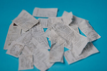 Pile of shopping receipts on blue background