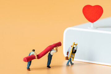 Miniature people Labor Worker walking carry ladder and red carpet for decorate stage with red heart using as special event making service business or Valentine day 14 February Lovely Happy Family idea