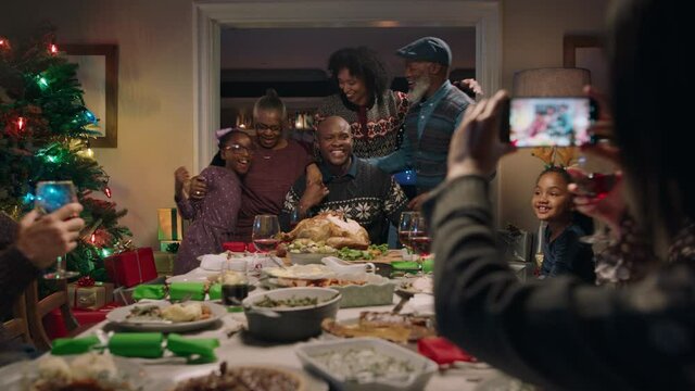 african american family posing for photo at christmas dinner friends using smartphone photographing festive reunion gathering celebrating holiday season at home 4k