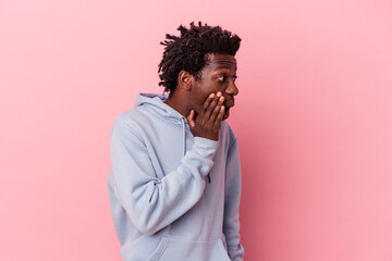 Young african american man isolated on pink background being shocked because of something she has...