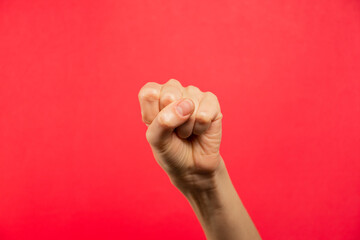 Mano puño cerrado, fondo rojo.