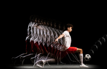 Portrait of young professional football player isolated on black background playing. Stroboscope...