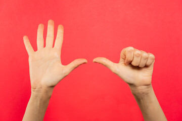 Mano numero 6, señal numero 6, fondo rojo.