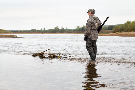the hunter crosses the river in shallow water