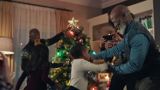 african american grandfather dancing with little girl on christmas eve happy child having fun dance with grandpa enjoying family holiday celebration at home 4k