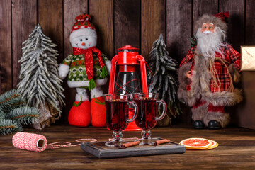 Christmas mulled red wine with spices and fruits on a dark table.