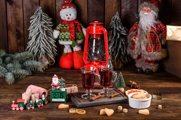 Christmas mulled red wine with spices and fruits on a dark table.
