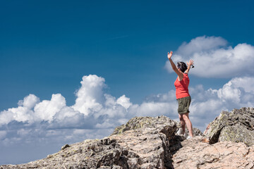 Fototapeta premium Woman looking down on the valley from a mountain top