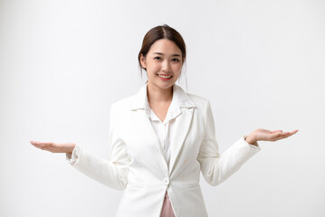 Smiling young business Asian woman in white suit showing two open hand palms with copy space for product or text, isolated on white background