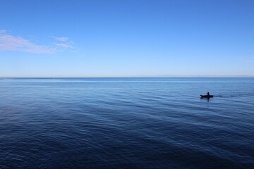 kleines Kajak im Meer mit blauem Himmel 