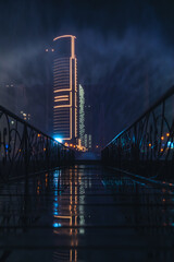 Beautiful luminous night photo on a skyscraper across the bridge of singing fountains, Batumi, Georgia