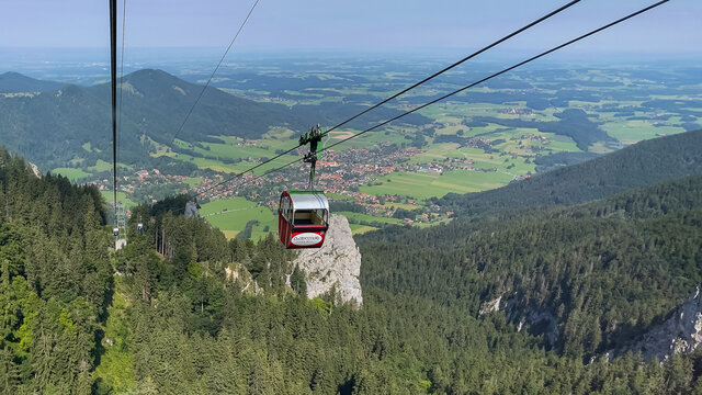Downhill view from a red ropeway from the Chiemgau Kampenwand down to the city Aschau in the southern bavaria germany alps region.