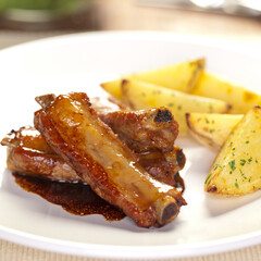 Costelinhas assadas com batatas organaicas com salpicada com salsinha