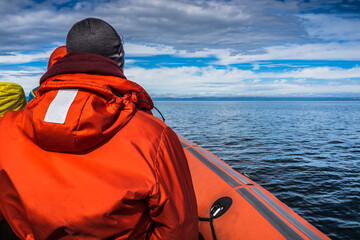 Passenger of an inflatable boat with their life jacket on whale watching cruise on Tadoussac,...