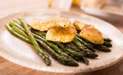 cooked dish. Chicken nuggets with green asparagus on plate