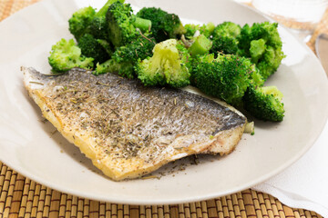 dish of fried dorado fish fillet with boiled broccoli