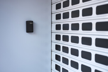 closed shutter of a store with an electric lock on the wall