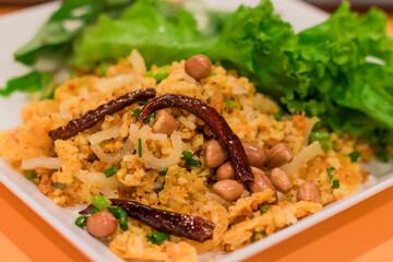 Thai style fried rice salad in a dish topped with fried vegetables and chilli