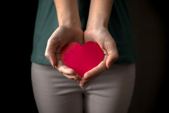 Woman giving red heart gesture. Hand with red heart. Health insurance, organ donor day and charity concept photo