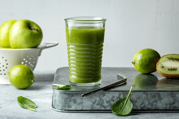 Green vegan smoothie with ginger and spinach in glass.  Clean eating, detox, dieting, vegetarian, vegan,  healthy weight loss food concept