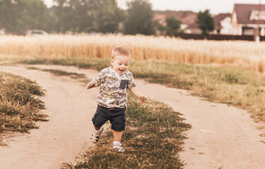 Little boy running down a rural road in summer