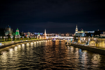 Fototapeta premium landscape with night river lights reflected in the river and the ancient Kremlin with towers on the bank 