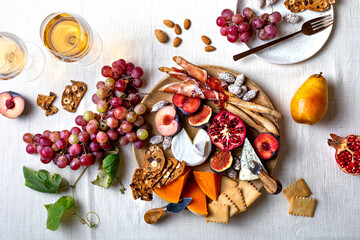 Appetizers table with italian antipasti snacks or authentic traditional spanish tapas set. Fall fruit, cheese and meat variety board. Top view, flat lay
