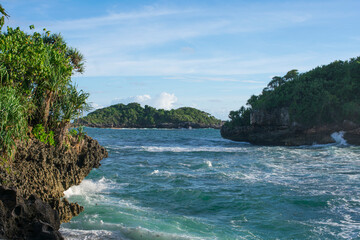 A beach with a small island with sunny weather.