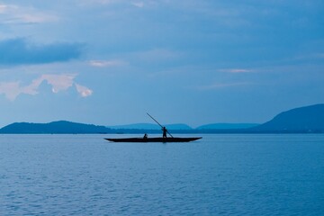 A silhouette of fisherman fishing during the dusk.