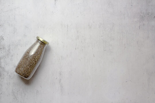 Glass Bottle Filled With Chia Seeds Stored With Essential Nutrients On A Rusty Wall Background