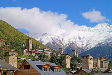Fototapeta na wymiar Amazing Medieval Svan Tower-houses in the Town of Mestia with Snow-capped Caucasus Mountain in the Backdrop, Svaneti Region of Georgia