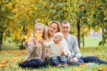 Naklejka na ściany i meble happy family on autumn picnic in park