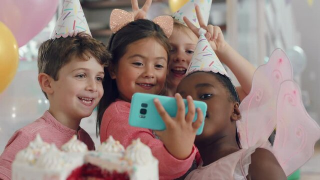 cute birthday girl using smartphone taking photo with friends happy children celebrating party posing for photos having fun with mobile phone camera 4k