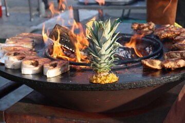 coconut and fresh meat cooking on metal plate
