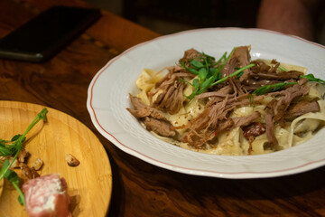 A plate of spaghetti with a beef on the table