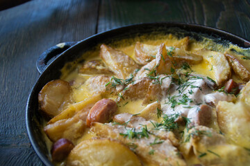 A pan of baked sausages and potatoes, with sour cream souse and fennel