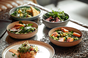 Table served with variety of different gourmet salad bowls