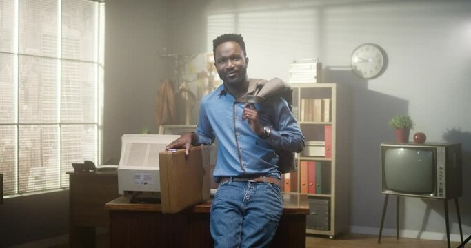Came to work. Waist up portrait view of the multiracial man looking at the camera and holding his case while standing near his workplace