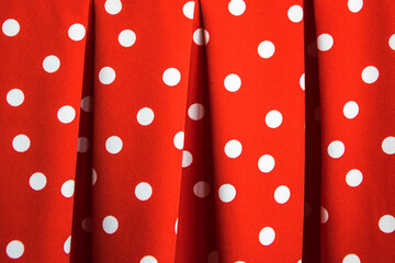 Red fabric with white polka dots, gathered in folds