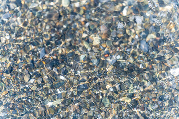 Background of wet pebbles washed by a sea wave