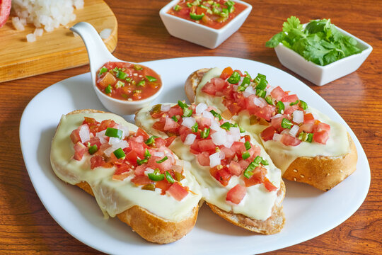Molletes, t&iacute;pica comida mexicana con salsa pico de gallo, frijoles y queso manchego para el desayuno o comida.