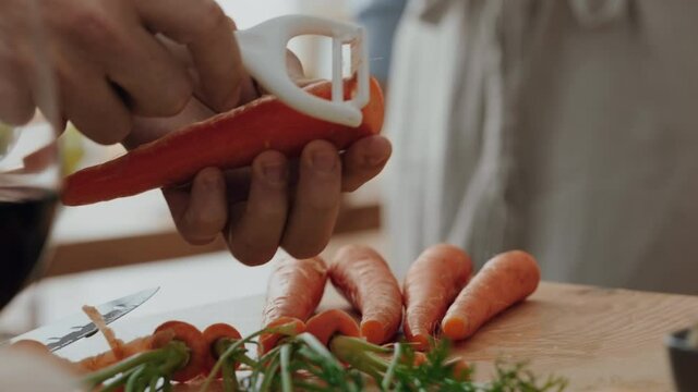 close up hands peeling carrots preparing fresh homemade meal with vegetables for cooking healthy organic lifestyle at home 4k footage