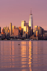Fototapeta na wymiar New York, NY - USA - Vertical image of the skyline of Lower Manhattan at sunrise, with reflections seen in the Hudson River. Highlighting the World Trade Center.