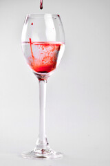halloween drink, czerwona woda w kieliszku, krople czerwonego płynu w kieliszku z wodą