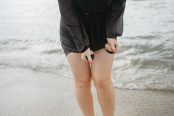 female legs, wringing out a wet black dress