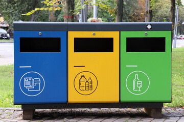 Multicolored recycling bins in the park. Outdoor garbage containers for plastic, paper, glass 