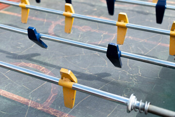Foosball game with blue and yellow dolls